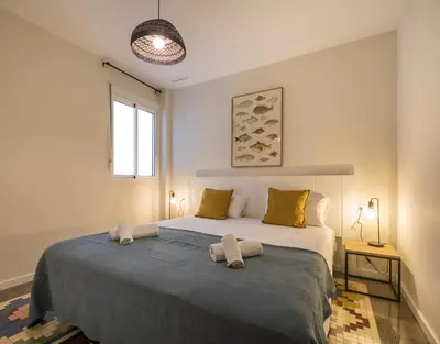 a bedroom with a large bed with two towels on it at Macflats Ayuntamiento in Valencia