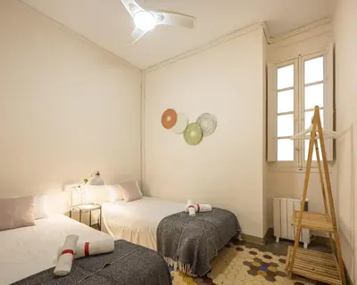 a small bedroom with two beds and a window at Macflats Ayuntamiento in Valencia