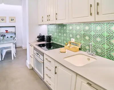 a kitchen with white cabinets and a sink and a table at Splendid houses in Valencia in Valencia