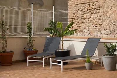 a patio with a table and chairs and potted plants at New Aloha Apartment Center with terrace Valencia in Valencia