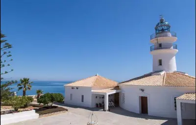 a lighthouse on top of a building with the ocean at 