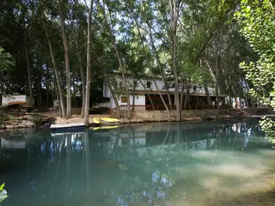 a house on the shore of a body of water at Molino Galán in Alborache