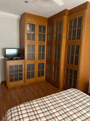 a bedroom with wooden cabinets and a bed and a television at Cristina Apartamento Center in Valencia