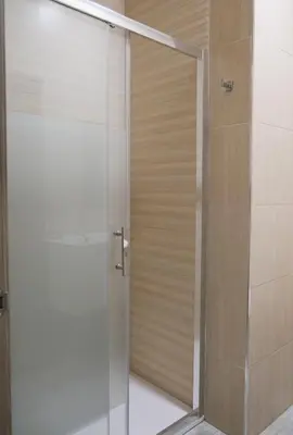 a shower with a glass door in a bathroom at Hostal Tartessos in Valencia