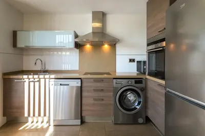 a kitchen with a washing machine and a washer at ApartUP Patacona Terrace Duplex I in Valencia