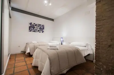 two beds in a room with white walls at Apartamentos La Xerea in Valencia