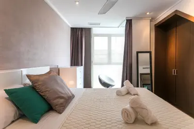 a bedroom with a large bed with towels on it at ApartUP Patacona Terrace Duplex II in Valencia