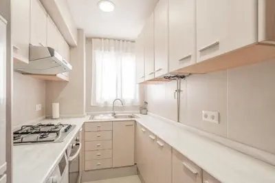 a white kitchen with white cabinets and a sink at 1ªLinea de playa Puerto de Sagunto in Puerto de Sagunto
