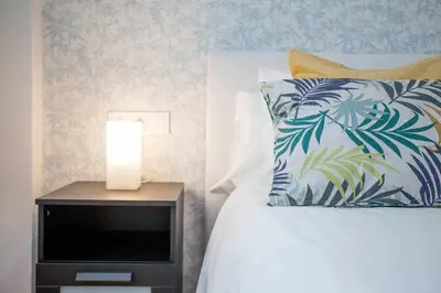 a bedroom with a bed and a nightstand with a lamp at Reus, Lovely Flat Close to Center in Valencia