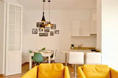 a kitchen and dining room with a table and yellow chairs at Hola Valencia - Holiday Apartments in Valencia