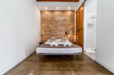 a bedroom with a bed and a brick wall at My Loft 4 You Ruzafa Style II in Valencia