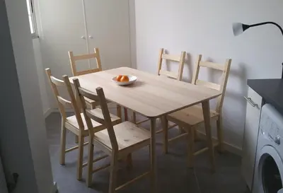 a wooden table with chairs and a bowl of fruit on it at Malvarossa apartment near beach in Valencia