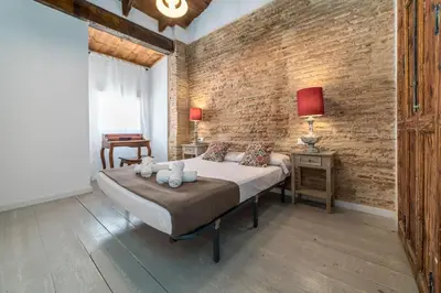 a bedroom with a bed and a brick wall at My Loft 4 You Ruzafa Style III in Valencia