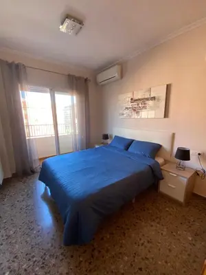 a bedroom with a blue bed and a window at Apartamento Ciencias y Playa in Valencia