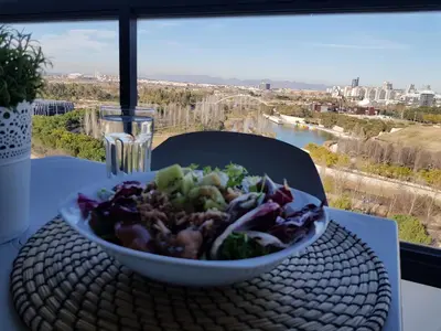 a bowl of salad sitting on a table with a view at River Park Valencia in Valencia