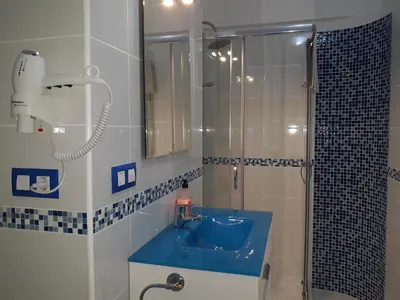 a bathroom with a blue sink and a shower at Belchite in Valencia