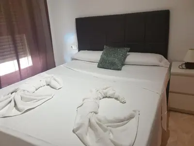 a bed with white towels on it with a pillow at Oceanográfico Apartments in Valencia