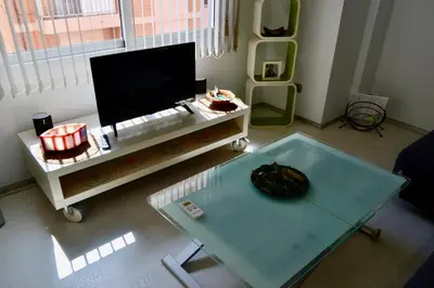a living room with a tv and a table at Oceanográfico Apartments in Valencia