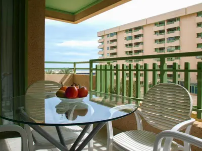 a glass table on a balcony with a bowl of apples at ApartUP Patacona Beach II in Valencia