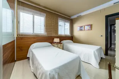 two beds in a room with white sheets at Travel Habitat Ático Ciutat Vella. in Valencia