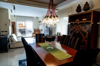 a dining room with a table and a chandelier at Travel Habitat Ático Ciutat Vella. in Valencia