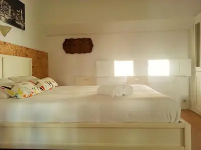 a bedroom with a white bed with towels on it at Valencian Dreams in Valencia