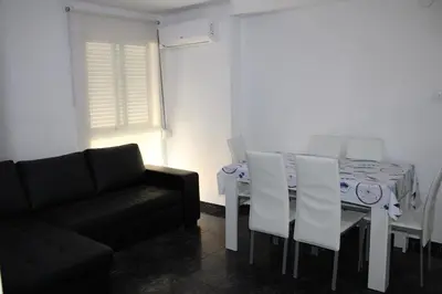 a living room with a table and a black couch at María montessori, pedagoga in Valencia