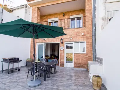 a patio with a table and chairs and an umbrella at Casa Esperanza in Alborache