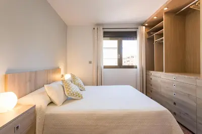 a white dining room with a white table and chairs at ApartUP Mestalla Home in Valencia