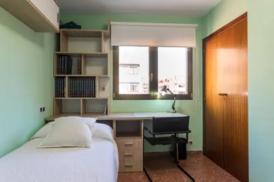 a bedroom with a bed and a desk and a bed and a sink at ApartUP Mestalla Home in Valencia