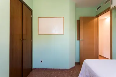 a bedroom with a bed and a wooden door at ApartUP Mestalla Home in Valencia