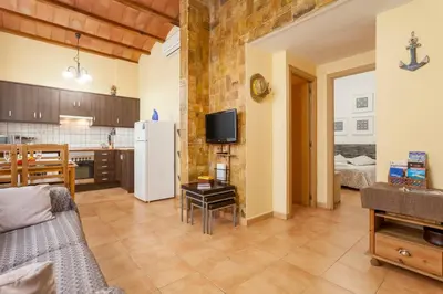a living room with a couch and a kitchen at Puerto Bello in Valencia