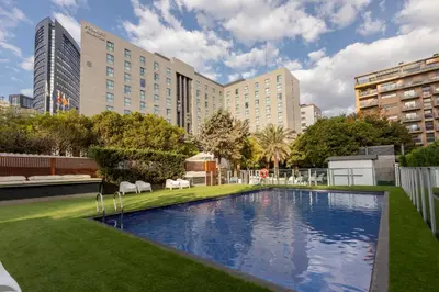 a large swimming pool in a city with buildings at Primus Valencia in Valencia