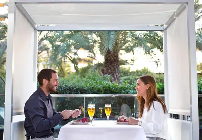 a man and woman sitting at a table with glasses of wine at Primus Valencia in Valencia