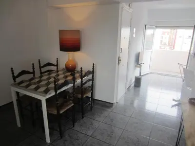 a dining room with a table and chairs and a lamp at Apartment 400 meters from the beach in Valencia