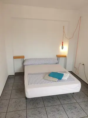 a white bed in a room with a lamp at Apartment 400 meters from the beach in Valencia