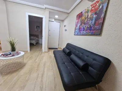 a living room with a black couch and a table at Vive Valencia con playa y metro cerca in Valencia