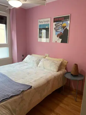 a bedroom with a bed and two posters on the wall at MÍ casa YOUR HOME in Valencia