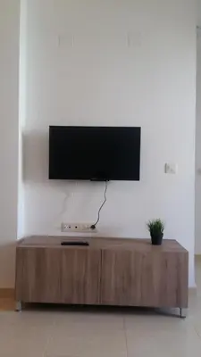 a flat screen tv on top of a wooden coffee table at El apartamento de Marina en Moncofar playa in Moncófar