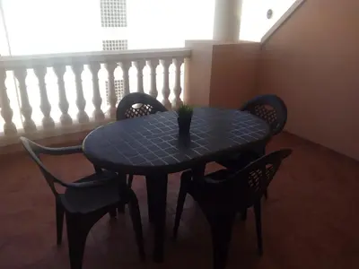 a blue table with chairs and a vase on it at El apartamento de Marina en Moncofar playa in Moncófar