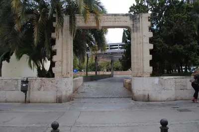 a stone archway in a park with a street at La Seda Stay in Valencia