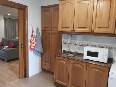 a kitchen with wooden cabinets and a microwave on a counter at Edificio Tiziano Mercado Central in Valencia