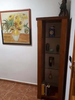 a book shelf next to a painting on a wall at Casa Pueblo Alzira No Compartida in Alzira