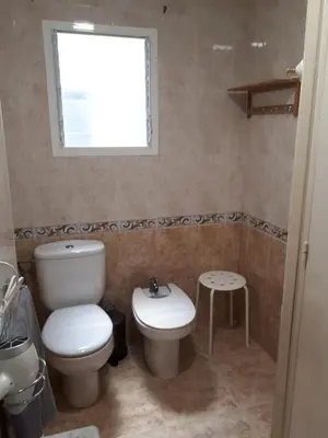 a bathroom with a toilet and a sink and a window at Casa Pueblo Alzira No Compartida in Alzira