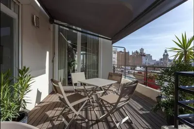 a patio with a table and chairs on a balcony at San Vicente in Valencia