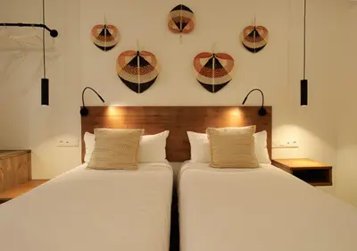 two beds in a room with hats on the wall at VALOLA Boutique Rooms in Valencia