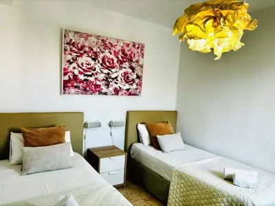 two beds in a room with a painting on the wall at Travel Habitat Jardines de Viveros in Valencia
