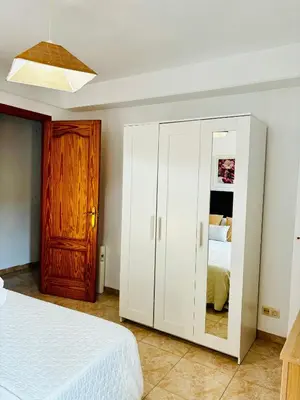 a bedroom with a white cabinet with a mirror at Travel Habitat Jardines de Viveros in Valencia