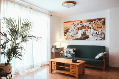 a living room with a green couch and a large window at Avinguda Mare Nostrum, 101 in Moncófar