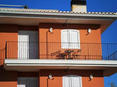 an orange building with white windows and a balcony at Apartamentos Concha del Mar in Sagunto